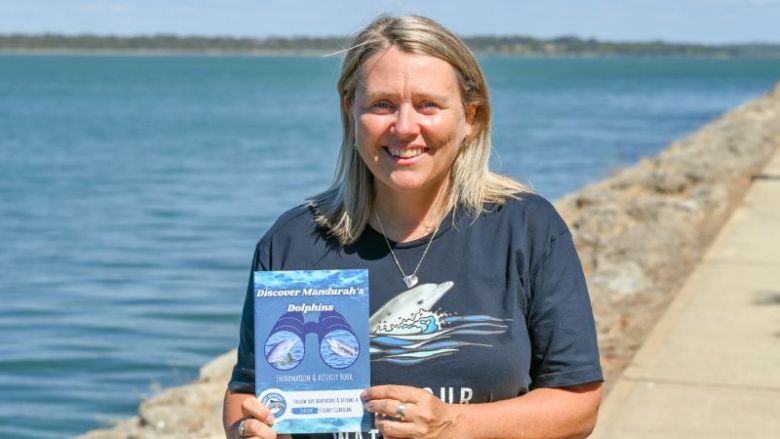 Women holding estuary educational book for children